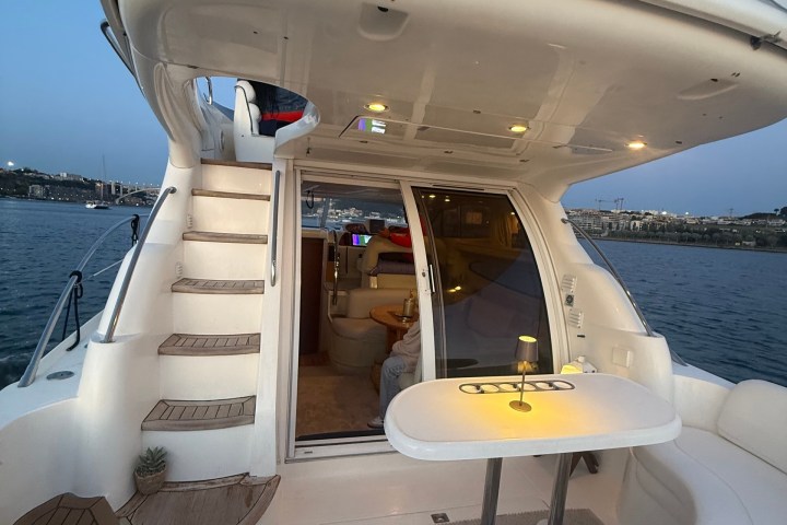 View of yacht's deck at sunset with open cabin doors.